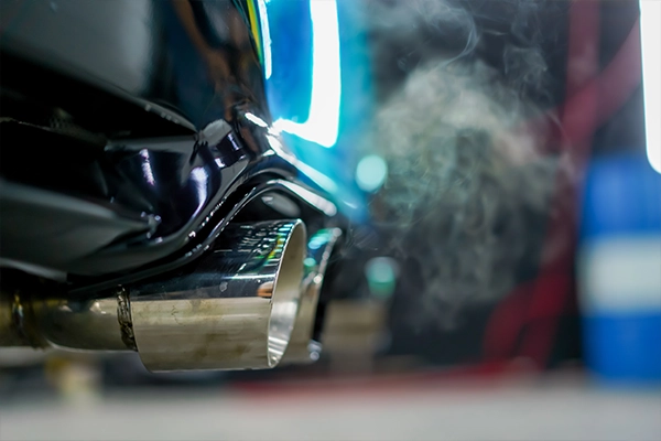 Close-up image of an exhaust emitting smoke 