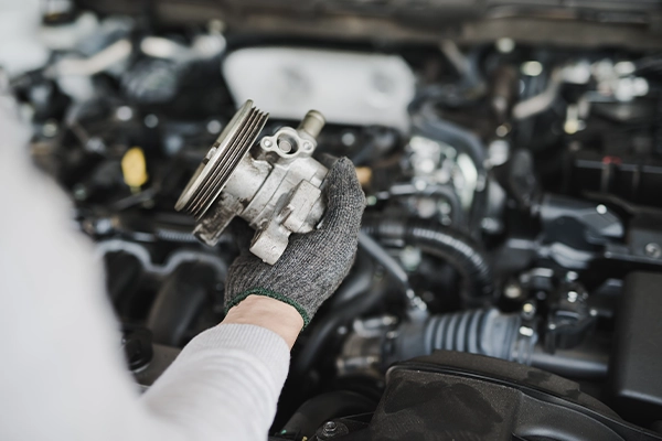 Technician holding power steering pump