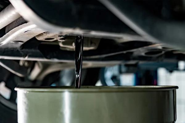 dirty oil being being drained into a funnel 