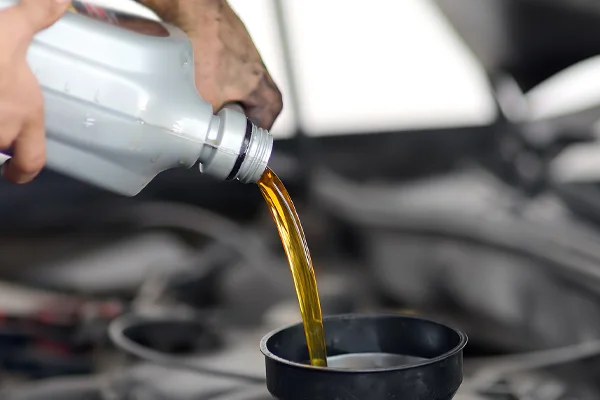 New motor oil being poured into a funnel 